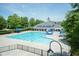 Community pool with lap lanes, clubhouse and sunbathing area on a beautiful day at 1013 Oatney Ridge Ln, Morrisville, NC 27560