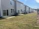 Backyard features a newly seeded lawn and the rear of a townhome with sliding glass doors at 106 S Chubb Rdg, Wilson's Mills, NC 27520