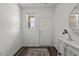 Bright entryway features wood-look floors, white walls, front door, window, and decorative mirror and console at 106 S Chubb Rdg, Wilson's Mills, NC 27520