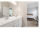 Bright bathroom featuring double vanity sinks and mirror and adjacent bedroom at 1073 Branch Line Ln, Apex, NC 27502