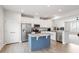 Bright kitchen features stainless steel appliances, white cabinets, and a blue island with granite countertop at 1073 Branch Line Ln, Apex, NC 27502