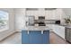 Modern kitchen boasting stainless steel appliances, white cabinetry, granite countertops, and a blue island at 1073 Branch Line Ln, Apex, NC 27502