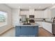 Bright kitchen features stainless steel appliances, white cabinets, and a blue island with granite countertop at 1073 Branch Line Ln, Apex, NC 27502