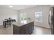 Contemporary kitchen featuring a granite island, laminate flooring, and seamless transition to the dining area at 1073 Branch Line Ln, Apex, NC 27502
