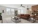 Staged living room featuring a ceiling fan and a brick accent wall with decorative shelving at 1073 Branch Line Ln, Apex, NC 27502