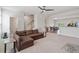 Bright, open-concept living room features neutral tones, modern ceiling fan, and seamless flow to dining area at 1073 Branch Line Ln, Apex, NC 27502