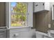 Bright bathroom view of the backyard through a window with white trim and a toilet nearby at 1112 Western Ave, Rocky Mount, NC 27804