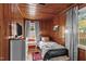 A compact bedroom features hardwood floors, wood walls, and a cozy bed next to the window at 1112 Western Ave, Rocky Mount, NC 27804