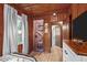 A small bedroom features warm wood walls, a wood floor, and access to another room at 1112 Western Ave, Rocky Mount, NC 27804