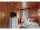 This quaint bedroom features wood floors and walls, plus neutral bedding and bright, natural light at 1112 Western Ave, Rocky Mount, NC 27804