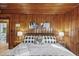 Comfortable bedroom with a black metal bed frame and rustic wood paneled walls at 1112 Western Ave, Rocky Mount, NC 27804