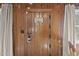 Rustic wooden front door featuring unique hardware and a decorative sign, flanked by neutral curtains at 1112 Western Ave, Rocky Mount, NC 27804