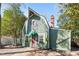 Charming green home featuring a unique roofline, complemented by a brick pathway leading to a quaint front door at 1112 Western Ave, Rocky Mount, NC 27804