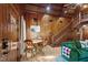 Rustic-chic living area featuring wood-paneled walls, dining area, staircase, and comfortable green seating at 1112 Western Ave, Rocky Mount, NC 27804