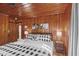 The main bedroom offers warm wood walls, hardwood floors, and a checkered bedspread at 1112 Western Ave, Rocky Mount, NC 27804