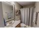 Well-lit bathroom featuring a single sink vanity and a shower with a gray curtain at 112 Tillburg Ln, Hurdle Mills, NC 27541