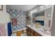 Bright bathroom features dual sink vanity, floral wallpaper, and hardwood floors at 112 Tillburg Ln, Hurdle Mills, NC 27541