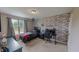 Bedroom with brick accent wall, gaming setup, neutral walls, and natural light at 112 Tillburg Ln, Hurdle Mills, NC 27541
