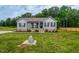 Charming home with manicured lawn, covered front porch, and stone landscaping features at 112 Tillburg Ln, Hurdle Mills, NC 27541
