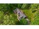 An aerial view reveals a well-maintained home and deck surrounded by a beautiful lawn and greenery at 113 Denard St, Oxford, NC 27565