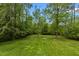 Lush green backyard surrounded by mature trees provides a peaceful, private outdoor space at 113 Denard St, Oxford, NC 27565