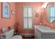 Charming bathroom with coral walls, shuttered window, and elegant vanity at 113 Denard St, Oxford, NC 27565