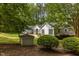 Quaint single-story home with black shutters surrounded by mature trees and manicured shrubs at 113 Denard St, Oxford, NC 27565