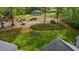 Aerial view of a manicured front yard with a large green lawn, mature trees, and a driveway at 113 Denard St, Oxford, NC 27565