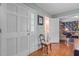 Hallway with hardwood floors leading to a bathroom and a floral-wallpapered room at 113 Denard St, Oxford, NC 27565