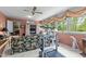 Bright sun room with a treadmill, floral sofa, tile floors, and large windows showcasing greenery at 113 Denard St, Oxford, NC 27565