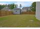 Fenced backyard featuring a shed with lawn and mulched planting areas at 1145 Raven Perch Dr, Wendell, NC 27591