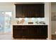 Stylish bar area with dark cabinetry, light countertops, and access to outdoor patio at 1145 Raven Perch Dr, Wendell, NC 27591