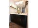 Bathroom features black vanity with double sinks, modern fixtures, and wood look floors at 1145 Raven Perch Dr, Wendell, NC 27591