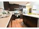 Well-lit kitchen with stainless steel appliances, dark wood cabinets, and island with white countertop at 1145 Raven Perch Dr, Wendell, NC 27591