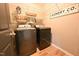 Functional laundry area with modern washer and dryer, wire shelving, and wood-look flooring at 1145 Raven Perch Dr, Wendell, NC 27591