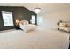 Spacious main bedroom with chandelier, neutral carpet, black accent wall, and natural lighting at 1145 Raven Perch Dr, Wendell, NC 27591