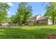 Large, grassy backyard with deck, patio, and wooden fence at 1207 Candlewood Dr, Elon, NC 27244