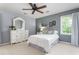 Bedroom features white bedspread, dresser and ceiling fan at 1207 Candlewood Dr, Elon, NC 27244