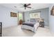 Cozy bedroom with neutral walls, a ceiling fan, and a large window providing natural light at 1207 Candlewood Dr, Elon, NC 27244