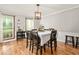 Elegant dining room with a classic table, chairs, wood floors, and two windows for natural light at 1207 Candlewood Dr, Elon, NC 27244