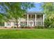 Charming two-story home with classic design, a well-manicured lawn, mature trees and lush landscaping at 1207 Candlewood Dr, Elon, NC 27244
