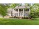 Traditional home with manicured lawn, black shutters, large columns, and lush landscaping at 1207 Candlewood Dr, Elon, NC 27244