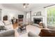 Bright living room featuring neutral colors, wood floors, fireplace, and natural light at 1207 Candlewood Dr, Elon, NC 27244