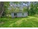 Exterior view of the back of the home with green grass and mature trees at 1219 Junction Rd, Durham, NC 27704