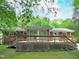 A spacious back deck, perfect for entertaining, with stairs, railing, and views of lush backyard greenery at 122 E Orange St, Hillsborough, NC 27278