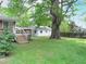 Expansive backyard features a large tree, well-manicured lawn, and a deck leading to the house at 122 E Orange St, Hillsborough, NC 27278