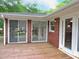 Wooden deck extends from the red brick house with multiple sliding glass doors at 122 E Orange St, Hillsborough, NC 27278