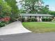 A well-manicured lawn and long driveway add curb appeal to this home with mature trees and bushes at 122 E Orange St, Hillsborough, NC 27278