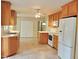 Eat-in kitchen featuring tile flooring, wood cabinets, white appliances, and a ceiling fan at 122 E Orange St, Hillsborough, NC 27278