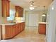 Bright kitchen with tile floors, wooden cabinetry, and white appliances offers space for meal preparation at 122 E Orange St, Hillsborough, NC 27278